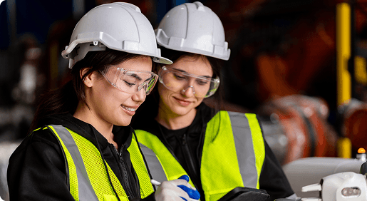 Two workers in hard hats and hi-vis reviewing a safety check on site